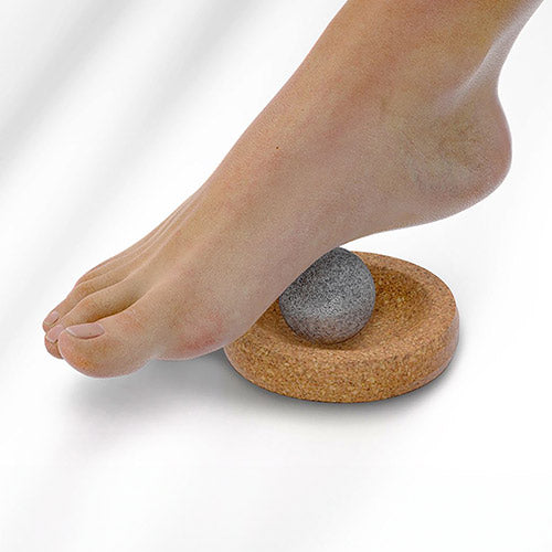 Hukka sauna massage sphere with gray stone ball on cork ring under foot for soothing sauna foot massage