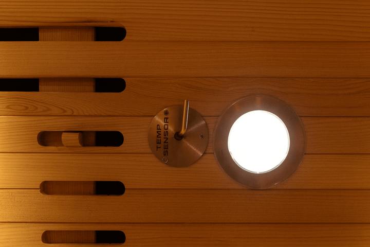 Interior view of a SunRay 1-person infrared sauna with temperature sensor and warm wood panels
