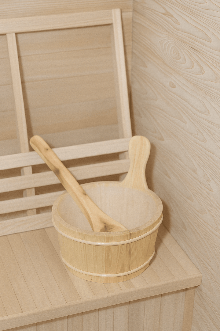 Traditional wooden bowl and ladle inside a SunRay 2-person home sauna for a relaxing experience