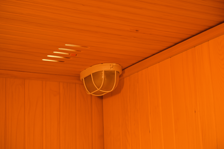 Interior view of a SunRay traditional sauna showcasing light fixture in a warm wooden ambiance