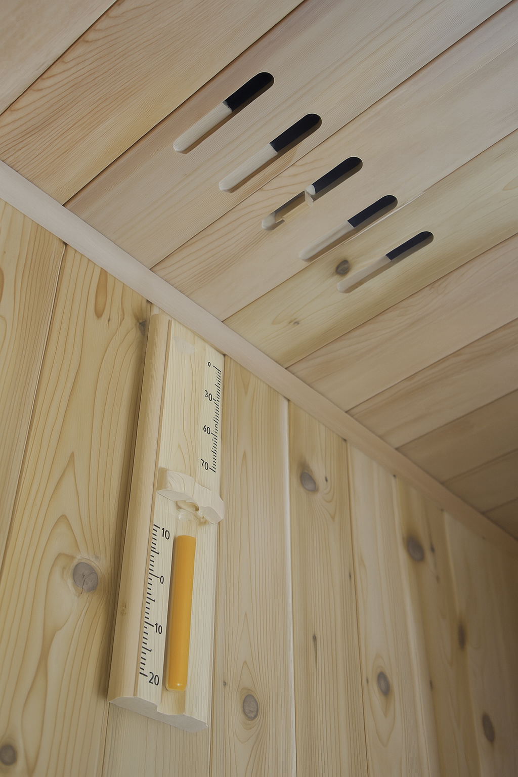 Close-up of wooden interior with thermometer and air vents in SunRay 3-person indoor sauna