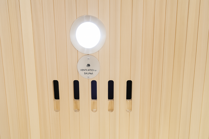 Control panel and light fixture inside SunRay 3-person infrared cedar sauna with wooden paneling