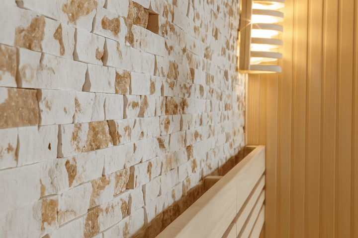 Interior of a SunRay 3-person traditional sauna featuring wooden walls and natural stone accents