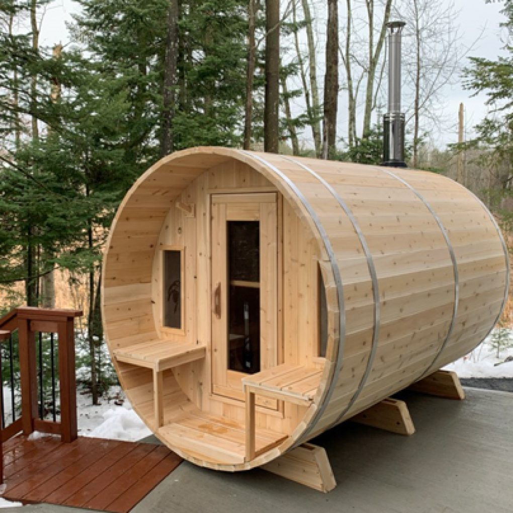 Leisurecraft Backyard Barrel Sauna for Sale made of natural wood with outdoor setup in a forested area
