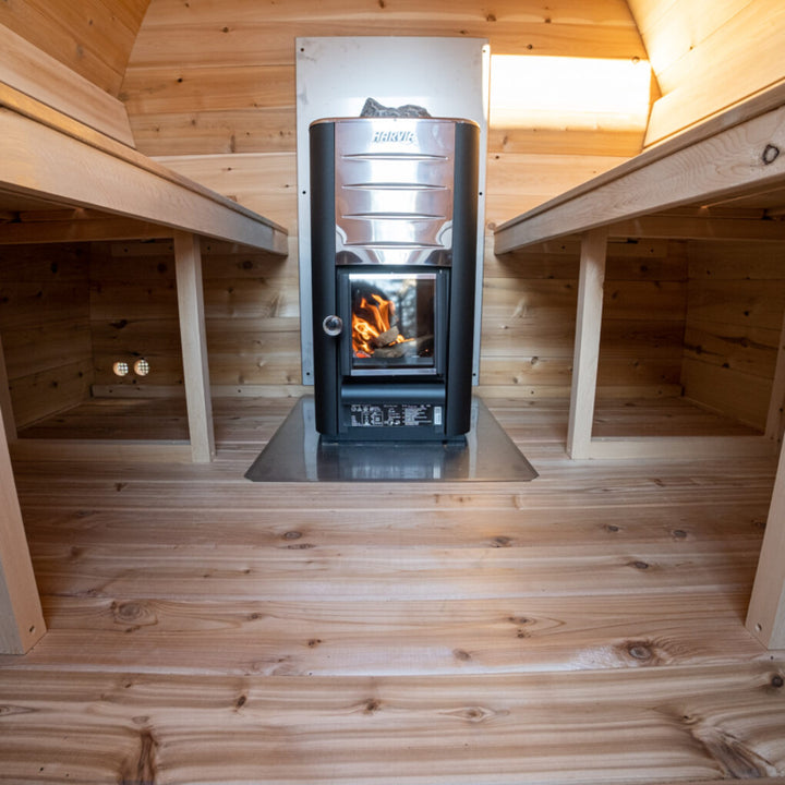 Leisurecraft traditional sauna interior featuring heater with fire and wooden benches for backyard saunas for homes