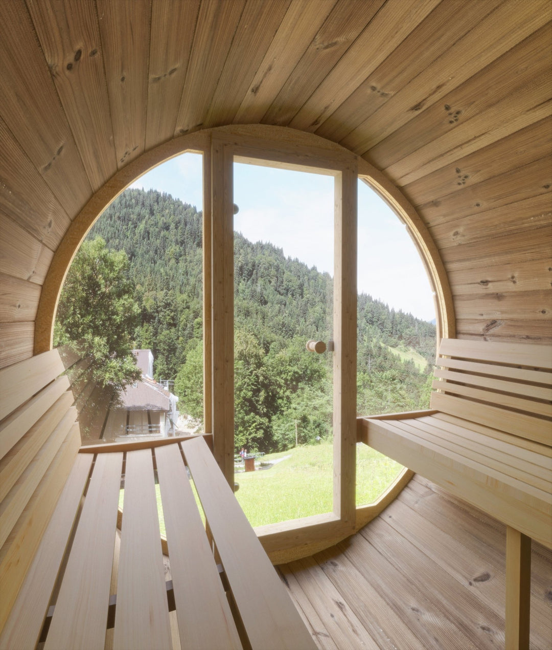 Barrel sauna with glass front showcasing a serene view of nature from inside the wooden interior