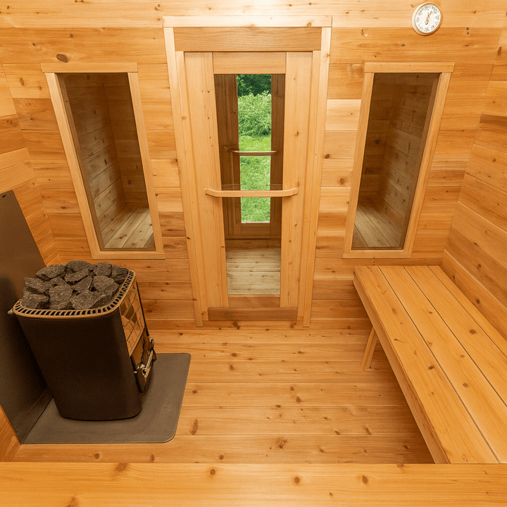 Interior of a Canadian Timber Georgian cabin sauna featuring warm wood tones and a stone heater