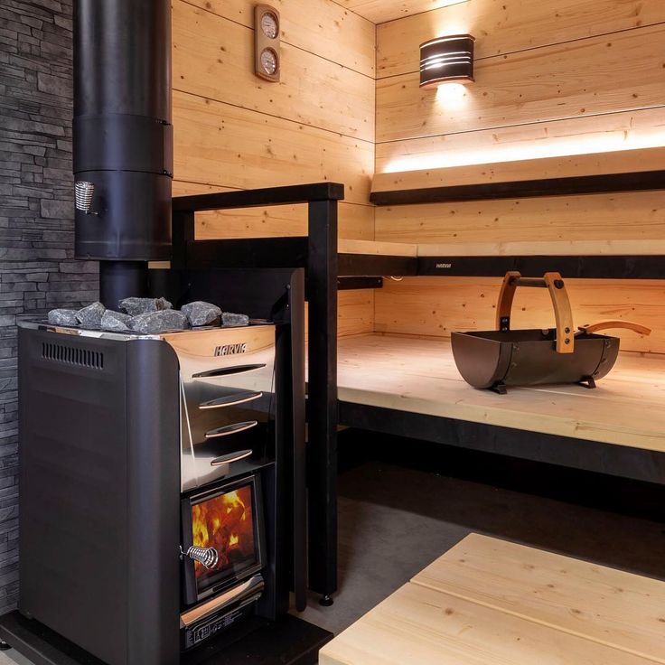 Harvia 26 Pro sauna heater with stones and visible flame inside, installed in a wooden sauna room