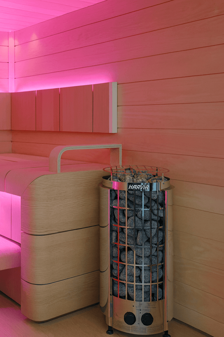 Harvia Cilindro PC90 sauna heater with stones in a stylish sauna interior with soft lighting