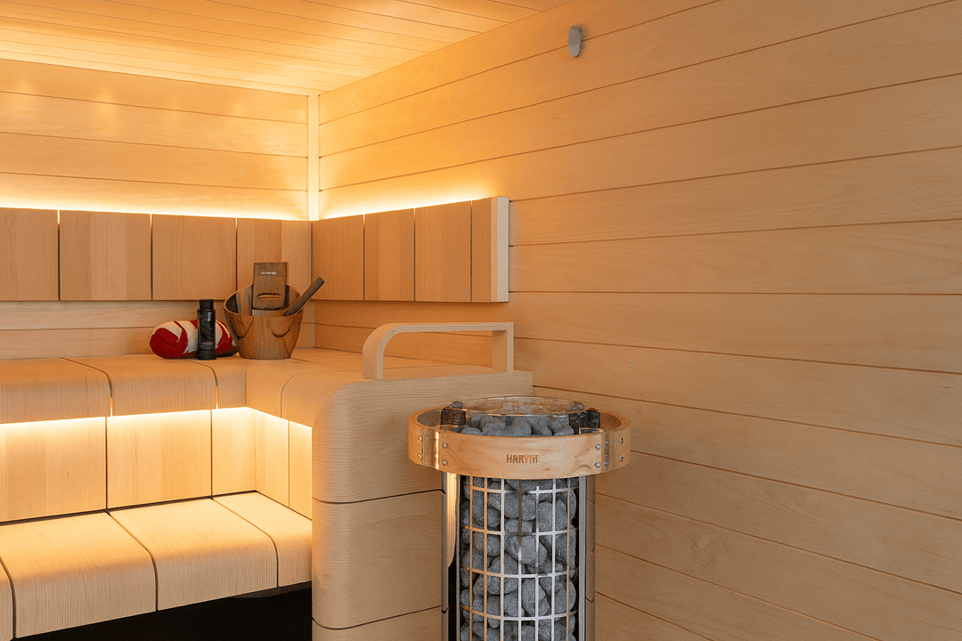 Harvia Cilindro PC90 sauna heater with stones in a modern wooden sauna interior