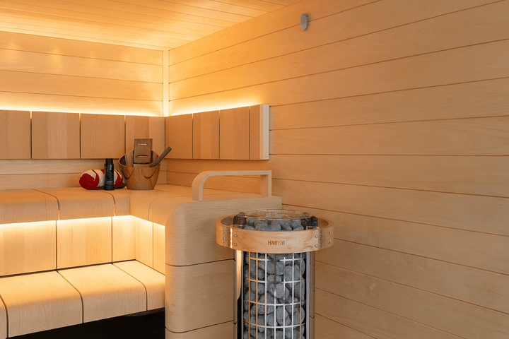 Harvia Cilindro PC90 sauna heater with stones in a modern wooden sauna interior