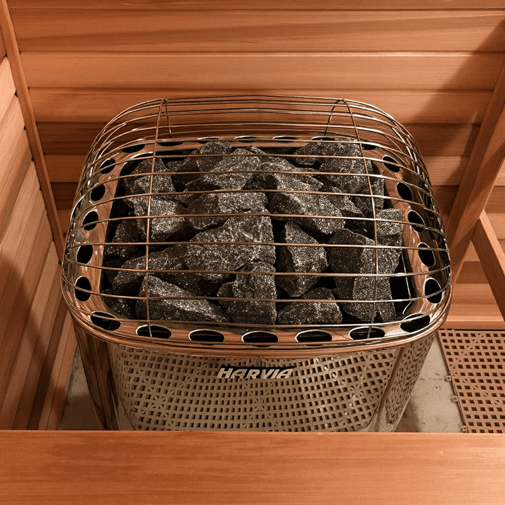 Harvia Club K15G 15kW sauna heater with heated stones in a wooden sauna environment