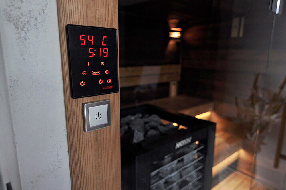 Harvia CX30C-U1 control package digital panel mounted on wooden frame near sauna heater