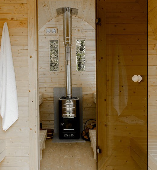 Harvia 1500 mm stainless steel chimney kit installed on black sauna stove inside wooden sauna cabin