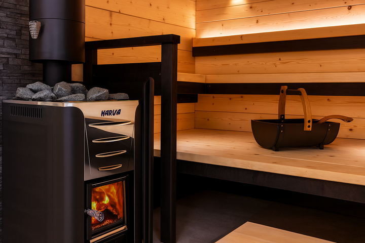 Harvia 26 Pro sauna heater with visible fire and stones inside modern wooden sauna with benches and ladle