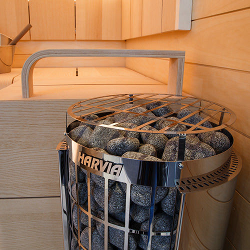 Harvia Cilindro PC60E electric sauna heater filled with stones in wooden sauna room