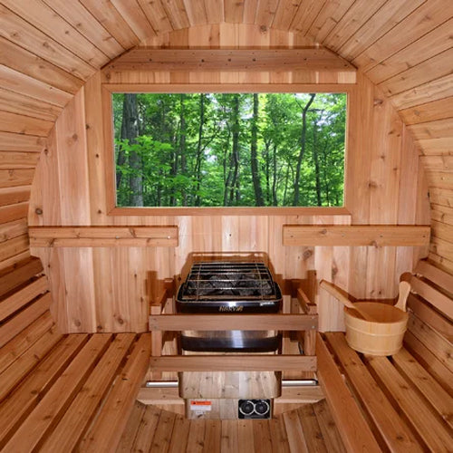 Harvia KIP30B electric sauna heater centered in cedar sauna cabin with wooden benches bucket and forest window view