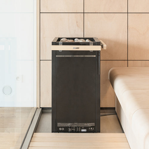Harvia Virta HL60E electric sauna heater freestanding black unit with stones on top in modern wood paneled sauna