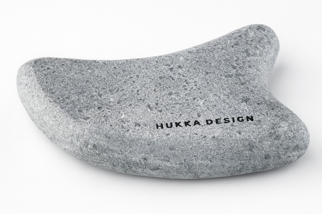 Hukka guasha massage stone for sauna in gray speckled ergonomic curved design with Hukka Design logo