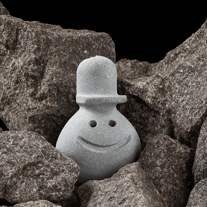 Hukka Reiska sauna elf decorative accessory made of stone, featuring a smiling face and hat design