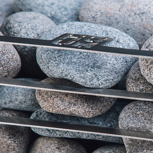 Close-up of sauna stones arranged inside the HUUM CLIFF 11kW electric sauna heater