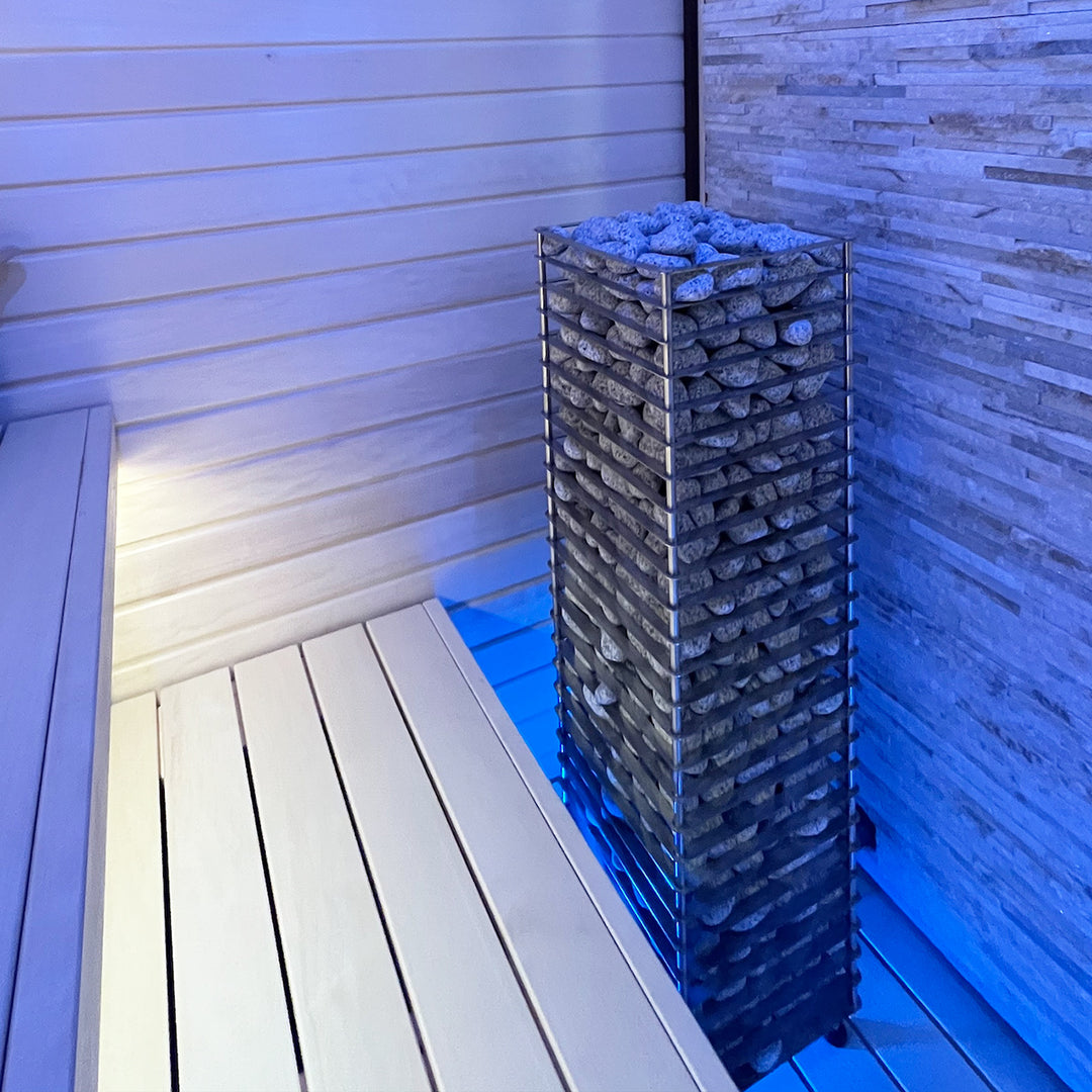 HUUM CLIFF 6kW sauna heater filled with stones inside a modern wooden sauna room