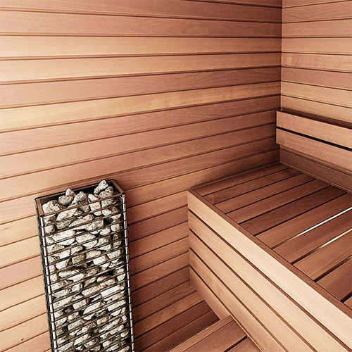 HUUM CLIFF Mini electric sauna heater with stacked sauna stones in a wooden sauna interior