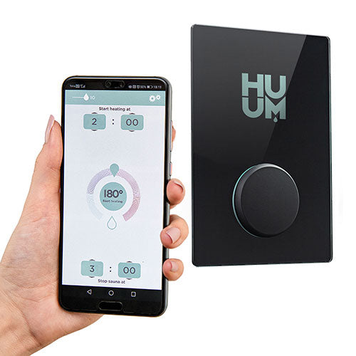 HUUM digital sauna control panel with black sleek design shown alongside smartphone app for remote sauna control