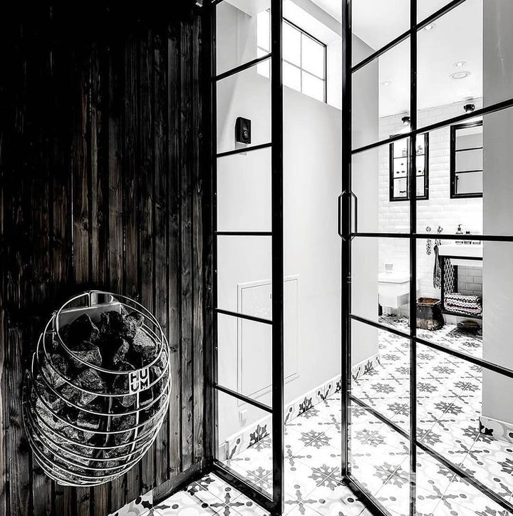 HUUM DROP 7.5kW sauna heater mounted on dark wooden wall inside modern sauna room