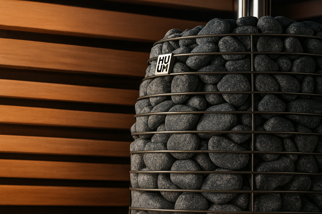 HUUM HIVE Flow Series sauna heater with stacked sauna stones and wooden wall panels