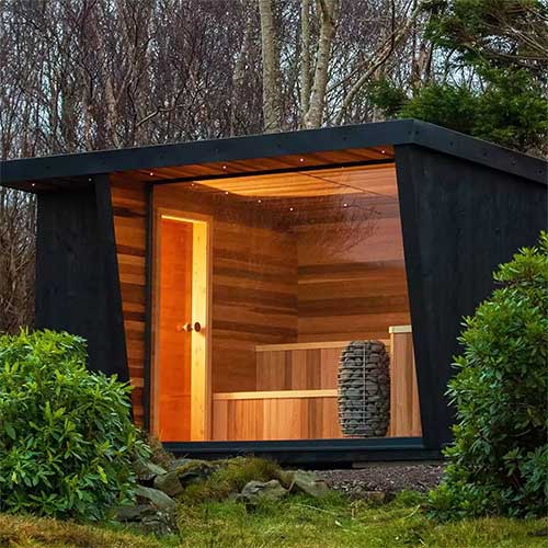 HUUM HIVE Mini 6kW sauna heater installed inside modern wood-paneled outdoor sauna cabin