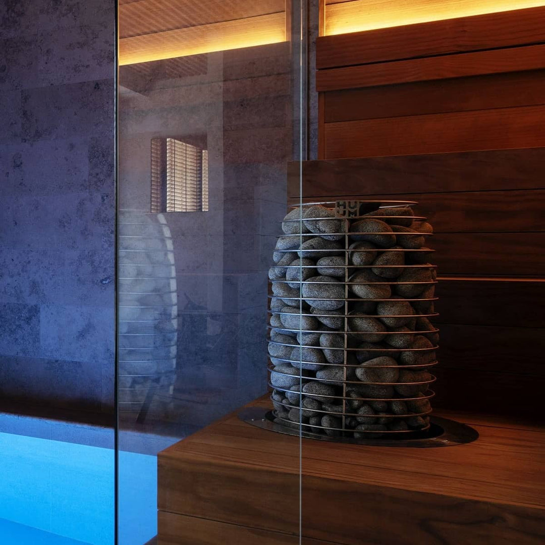 HUUM HIVE Mini 9kW electric sauna heater with stacked sauna stones inside modern wooden sauna room