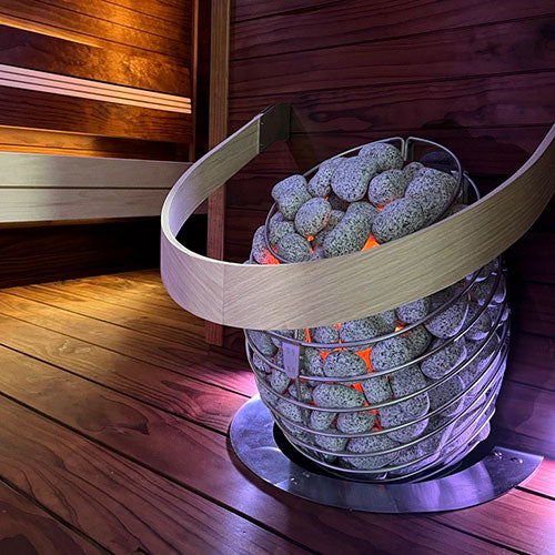 HUUM DROP 4.5kW sauna heater stainless steel basket filled with heated stones next to wooden sauna bench