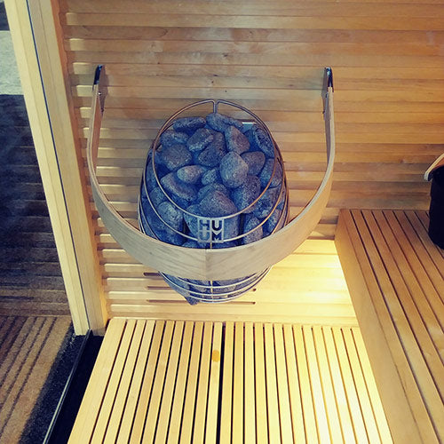 HUUM DROP 4.5kW sauna heater wall mounted steel stone basket in wooden sauna with bench lighting