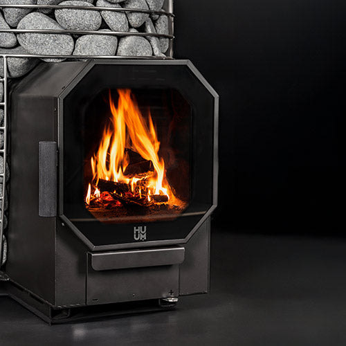 HUUM HIVE Heat Flow Mini 8.5kW black sauna heater with stone basket and visible wood fire through glass door