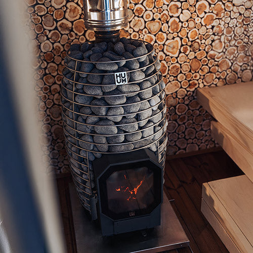 HUUM HIVE Heat Flow Mini 8.5kW sauna heater with stone filled cage and glass fire door in wood sauna