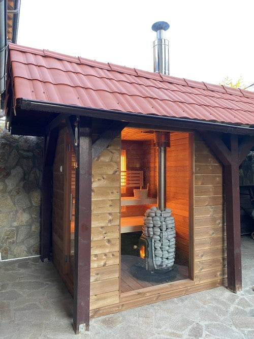 HUUM thru-ceiling chimney kit installed on a wooden sauna with red tiled roof and stone stove inside
