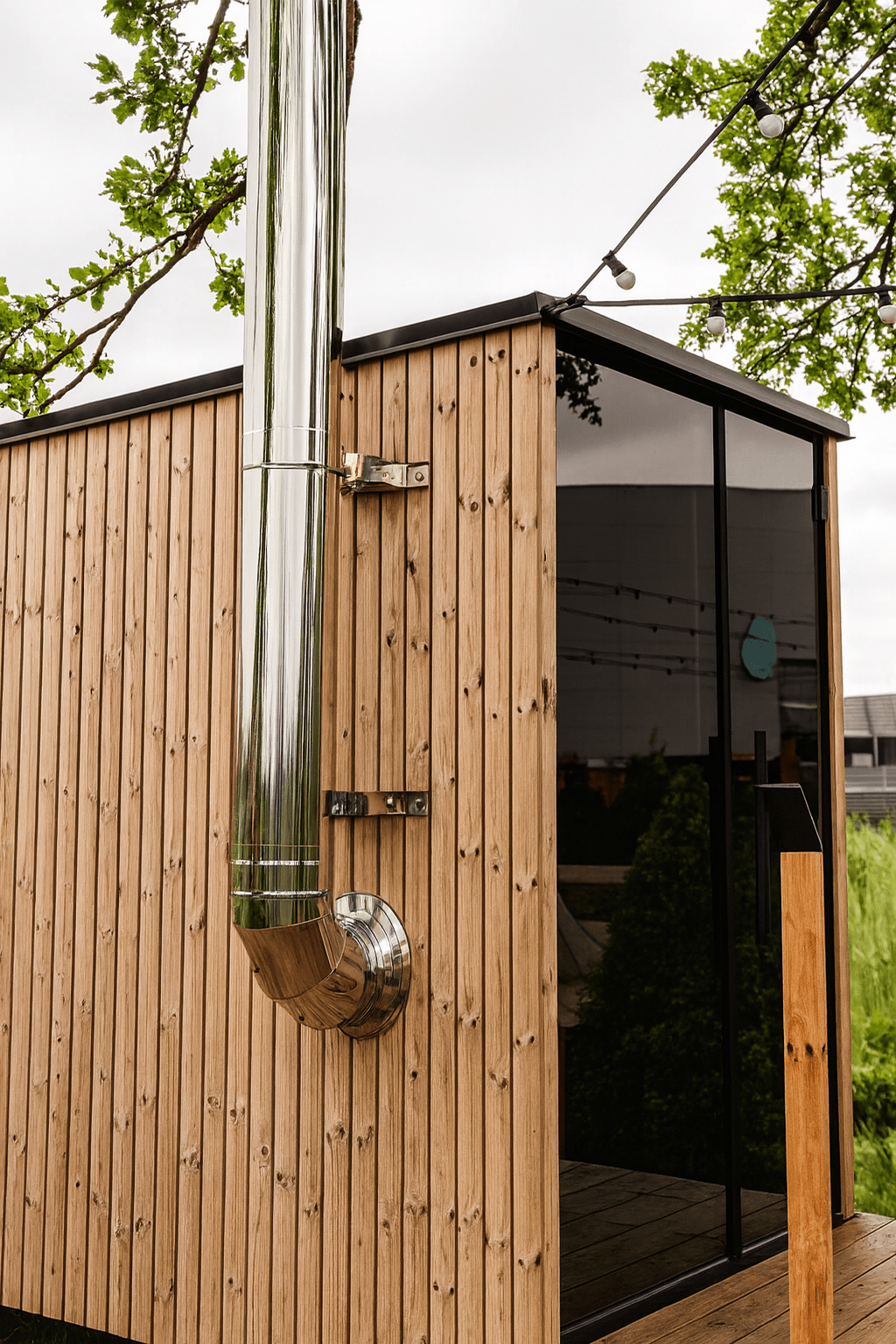 HUUM thru-wall chimney kit installed on a wooden outdoor sauna for efficient ventilation