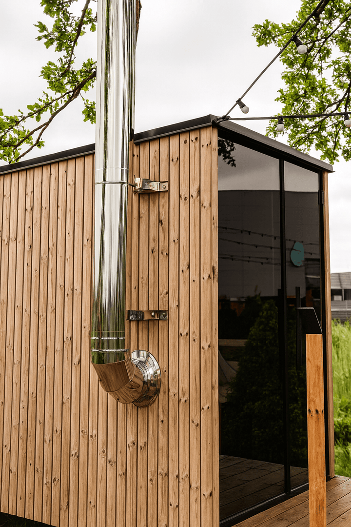 HUUM thru-wall chimney kit installed on a wooden outdoor sauna for efficient ventilation