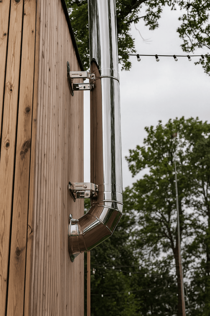 HUUM thru-wall chimney kit installed on a wooden exterior for efficient venting and heating