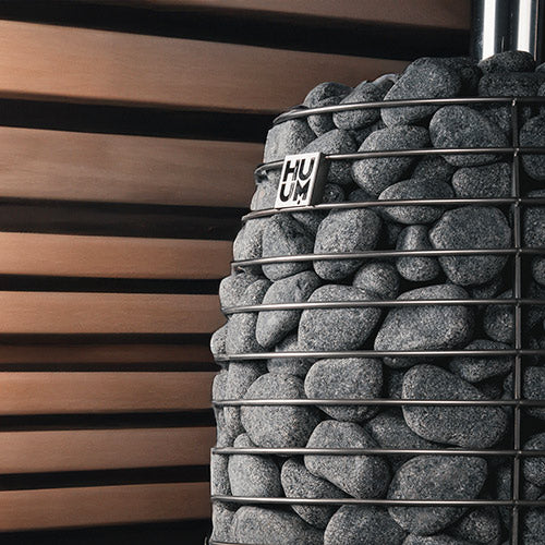 HUUM wood burning sauna stove filled with sauna stones inside wooden sauna room