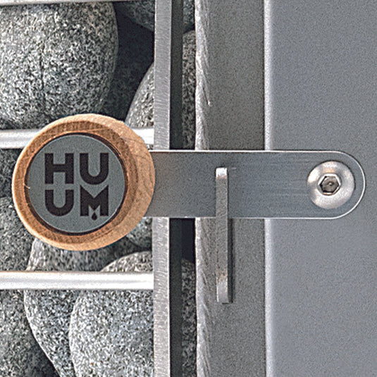 HUUM wood burning sauna stove close-up showing handle and sauna stones detail