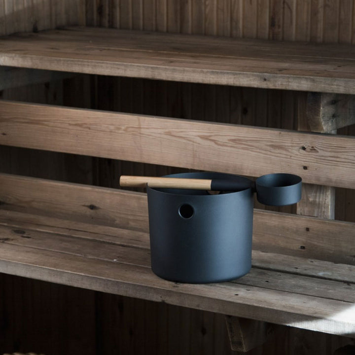 KOLO sauna accessories black water ladle and bucket set placed on wooden sauna bench