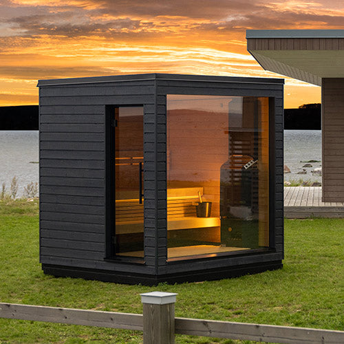 SaunaLife traditional luxury backyard sauna with large windows and modern black exterior at sunset