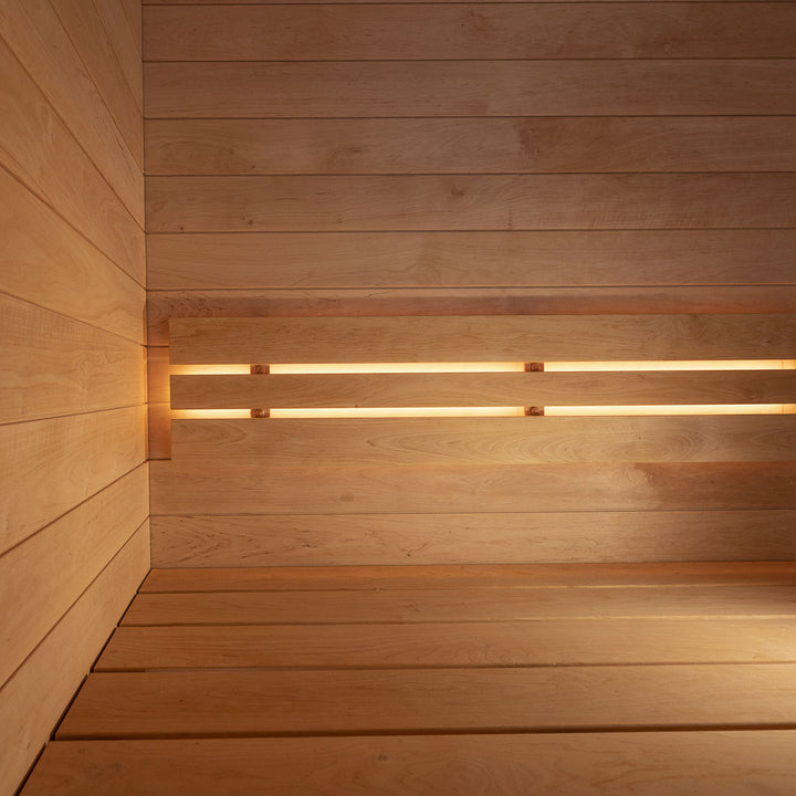 Interior wooden bench and wall of SaunaLife traditional luxury backyard sauna with warm lighting