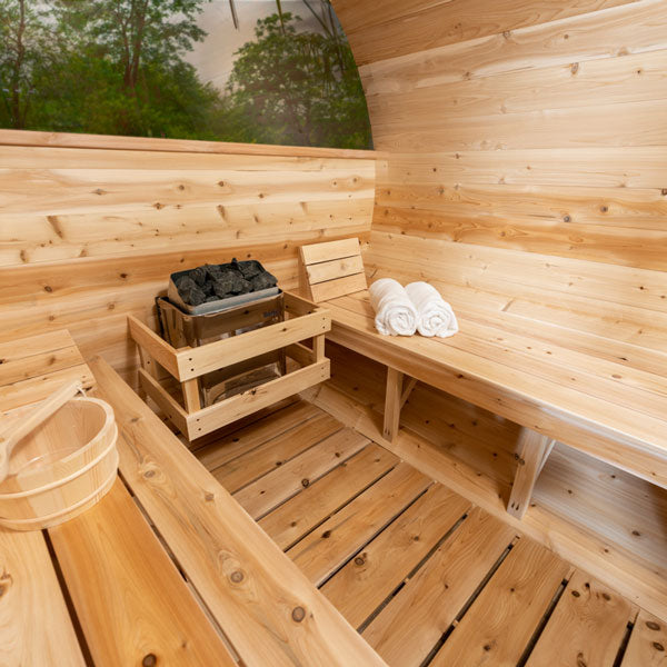 Interior view of Leisurecraft luxury barrel sauna with wooden benches and sauna heater