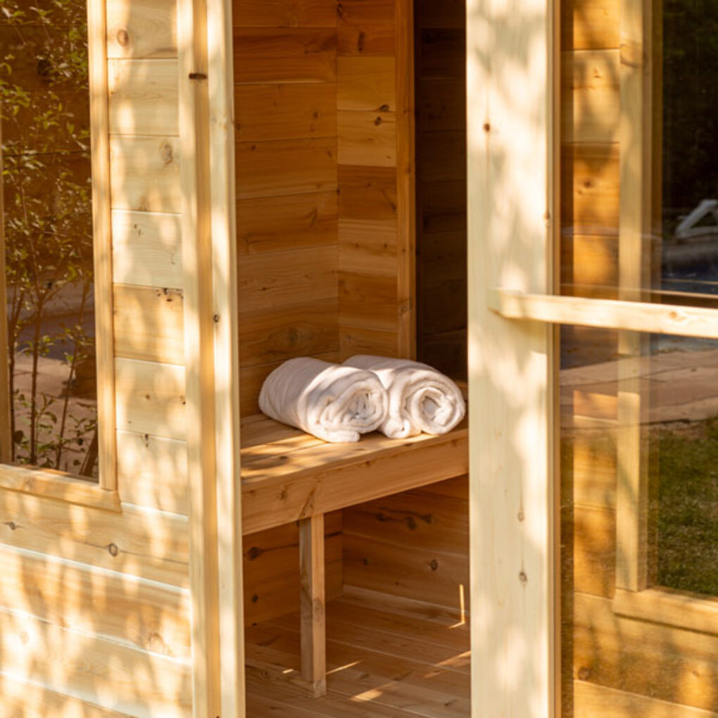 Interior view of Leisurecraft traditional luxury cabin sauna with wooden bench and rolled towels