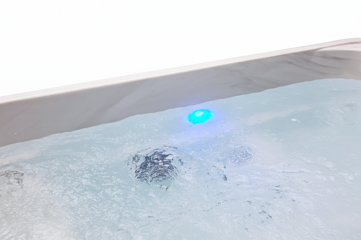 Luxury hot tub water gently bubbling with blue underwater LED light from Luxury Spa