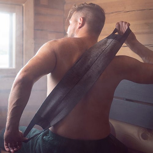 Man using luxury sauna back washer in a steam-filled sauna for effective cleansing