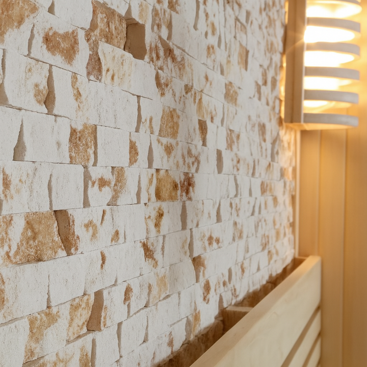Interior wall detail of SunRay luxury two-person sauna with textured stone tiles and wooden bench